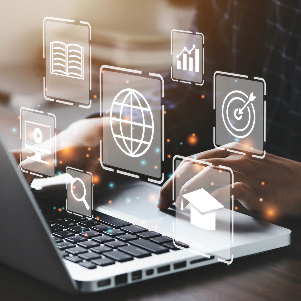 Tool icons floating above the hands of someone using a laptop keyboard.